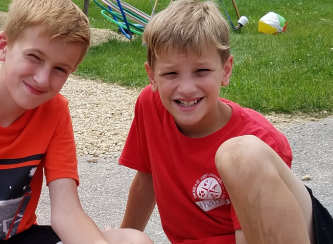 couple of kids smiling with craft in hand