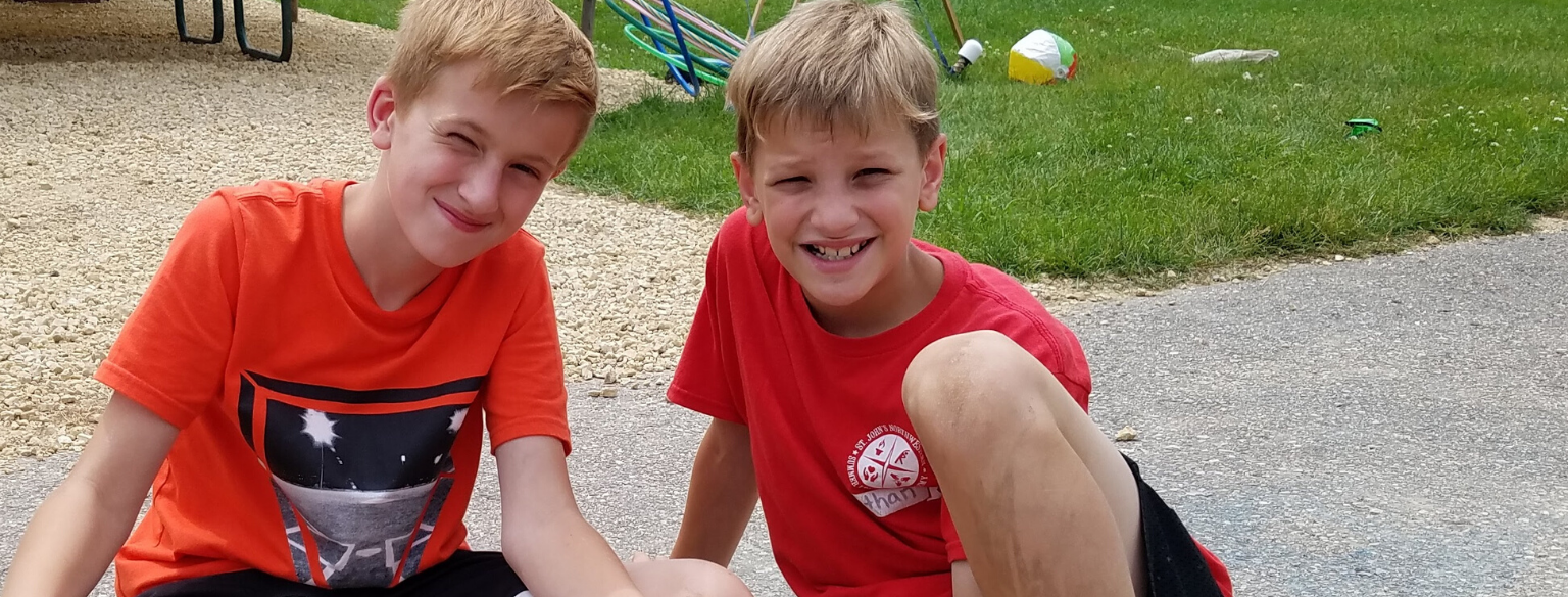 couple of kids smiling with craft in hand