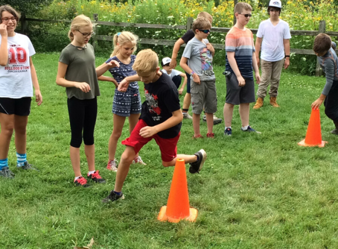 Kids racing around orange cones