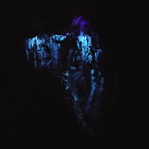 Formations fluorescing under a blacklight in a cavern in Wisconsin