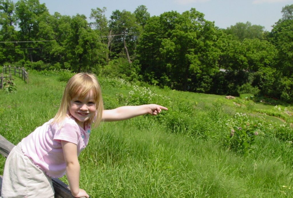 Photo of a girl pointing at the wonders along our nature trails.