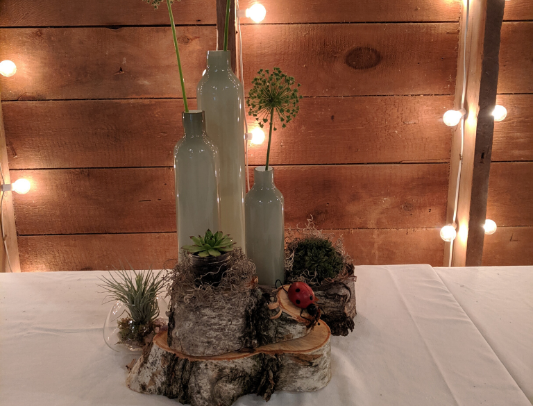 Centerpiece for an event with wine bottles and flowers