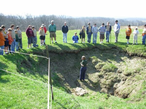 Photo of tour guide in sinkhole teaching scouts about karst typography