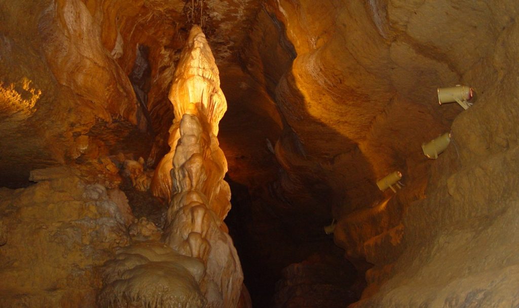 Large stalagmite in Cave of the Mounds with orange lighting