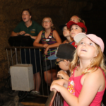 Photo of tour guide with kids in cave