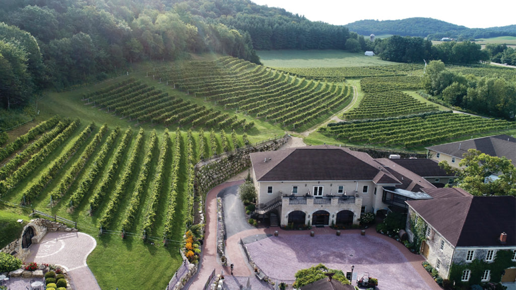 Wollersheim Vineyard main building with vineyard leading to the sunset