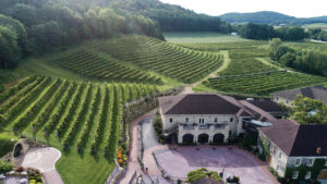 Wollersheim Vineyard main building with vineyard leading to the sunset