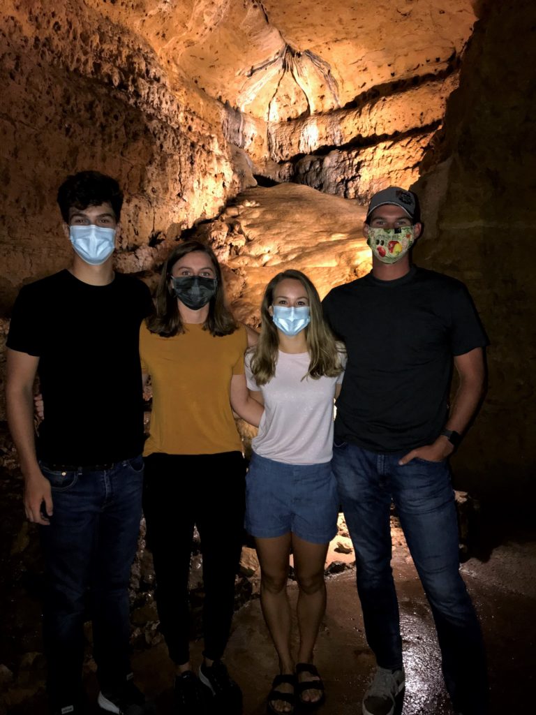 Group of four people standing in front of the North Cave Flowstone formation