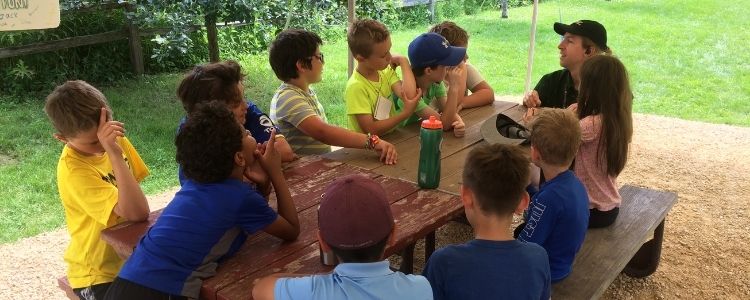 Guide talking to kids at picnic table