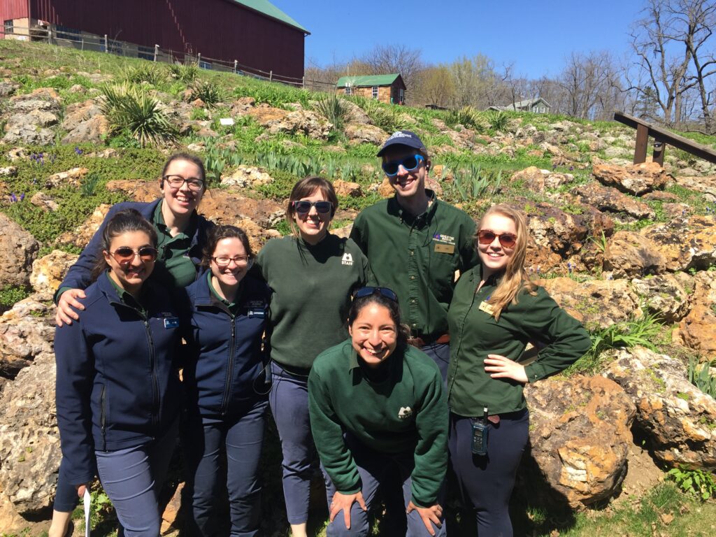 Group smiles at camera in sunglasses in front of Gardens near Chicago