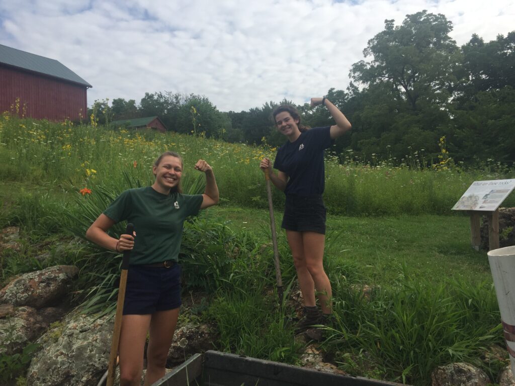 Two girls show off muscles from working in Wisconsin Garden near Madison