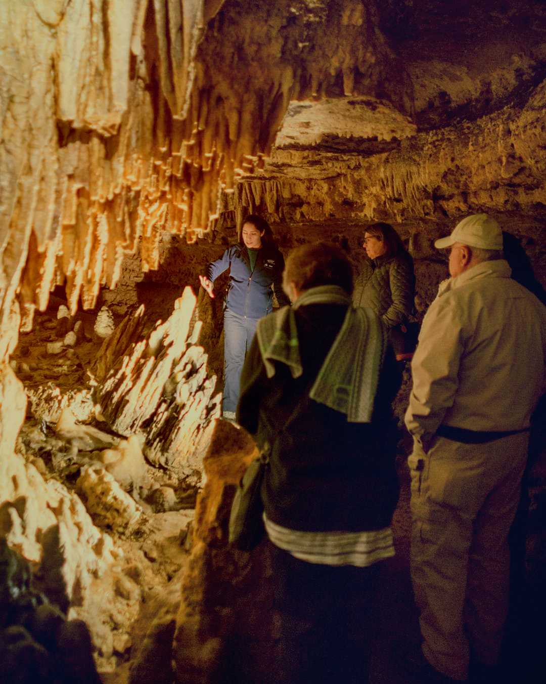 A tour guide leads a group in the cave, showing off cave formations