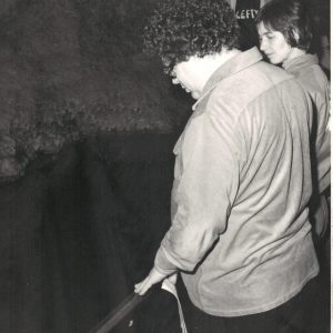 Man and woman look over railing to pond in Cave of the Mounds