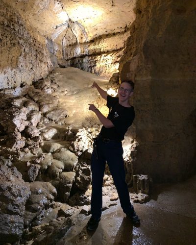 Photo of a tour guide pointing at some of our cave formations.