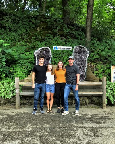 Group of four people in front of an amethyst cathedral at a midwest cave