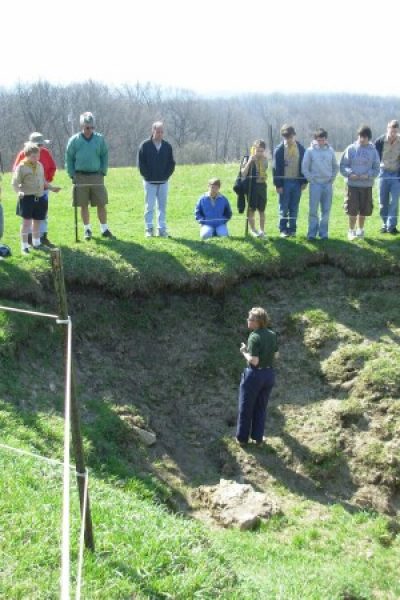 Photo of tour guide in sinkhole teaching scouts about karst typography